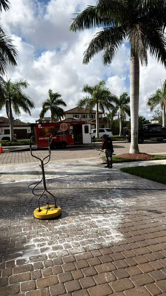 Surface cleaner pressure washing a brick paver driveway in Miami